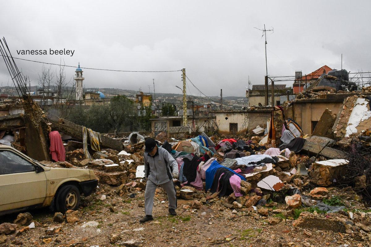 An old man chopping wood in front of his washing that he hung out to dry in the pouring rain. Photo: Vanessa Beeley