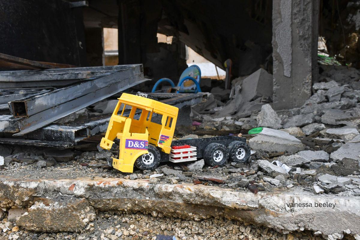A child’s toy truck among the remnants of the home they used to play in